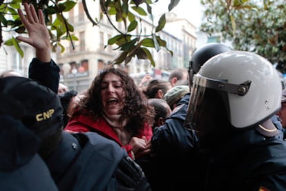 Una indignada intenta pasar el cordón policial que cortaba el acceso a la plaza del Carmen.