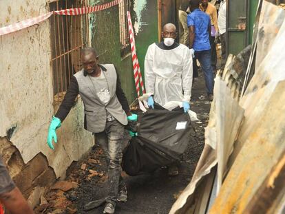 Dos personas transportan un cadáver tras el incendio en Monrovia, este miércoles en Monrovia.