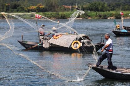 Un pescador arroja su red al río Fuchun en Hangzhou, en la provincia oriental china de Zhejiang.