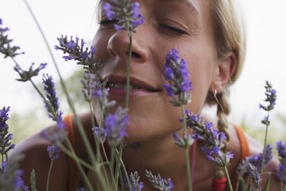 Un mujer huele lavanda. 