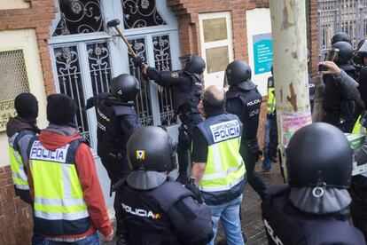 Agentes antidisturbios de la Policía Nacional a las puertas del Instituto Can Vilumara de L'Hospitalet de Llobregat (Barcelona).
