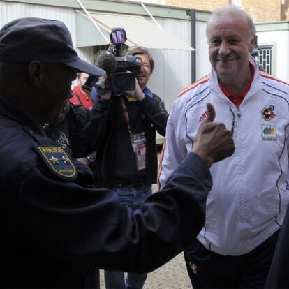 Un policía sudafricano saluda a Vicente del Bosque, pulgar en alto, después de pedirle que se identificara mientras paseaba sin acreditación en la ciudad deportiva de Potchefstroom.