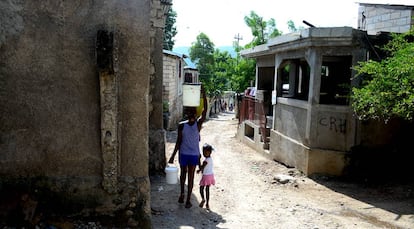 Una mujer carga con agua tras comprarla en un kiosko de Jacmel (Haití).