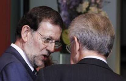 El presidente español Mariano Rajoy (i) conversa con el primer ministro italiano Mario Monti (d) antes de la foto de familia de la cumbre europea celebrada en Bruselas, Bélgica.