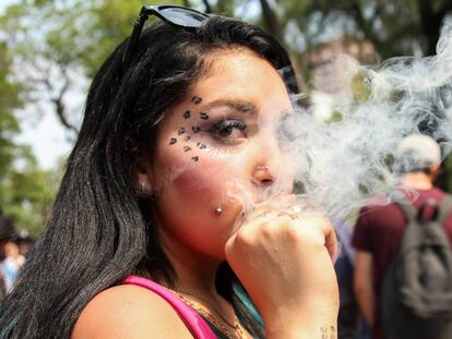 Una mujer fuma marihuana en una marcha a favor de la legalizaci&oacute;n.