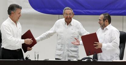 Juan Manuel Santos, presidente de Colombia y Rodrigo Londoño 'Timonchenko' se dan la mano durante una ceremonia para firmar el histórico acuerdo de paz entre el Gobierno colombiano y las FARC, el 23 de junio de 2016 en La Habana, Cuba. Los acompaña el presidente Raúl Castro.