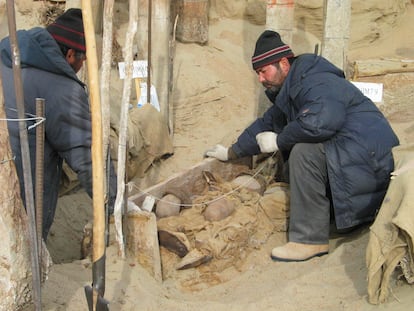 Escavação de uma tumba no cemitério de Xiaohe, no deserto de Taklamakan (China).