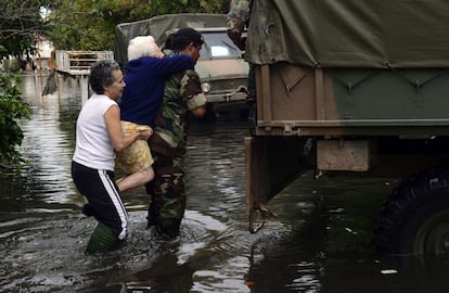 Un soldado evacua a una anciana en una calle inundada de La Plata (Argentina).