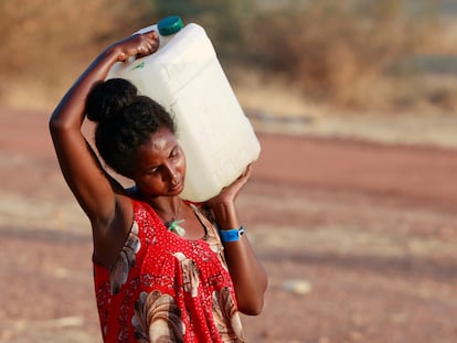 Una mujer etíope lleva un bidón de agua mientras camina en el campamento de Umrakoba, en la frontera entre Sudán y Etiopía.