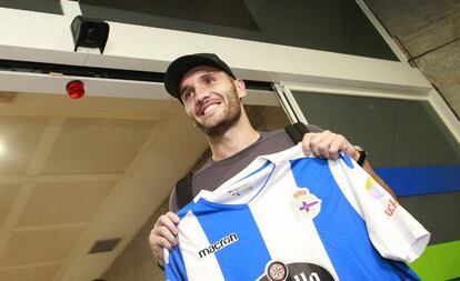 Lucas Pérez posa con una camiseta del Deportivo a su llegada al aeropuerto coruñés de Alvedro.