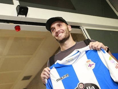 Lucas Pérez posa con una camiseta del Deportivo a su llegada al aeropuerto coruñés de Alvedro.