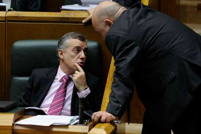 El parlamentario peneuvista Iñigo Iturrate (de pie) habla con el 'lehendakari' Urkullu en un momento del pleno.