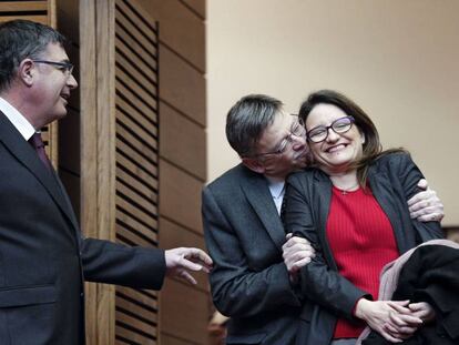 El presidente de la Generalitat valenciana, Ximo Puig, abraza a la vicepresidenta, M&oacute;nica Oltra, ante el presidente de las Cortes, Enric Morera.