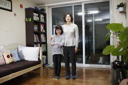 Kang Hyun-jeong, de 43 años, y su hija Yoo Ha-min, de 11 años, posan en la sala de estar de su apartamento en Seúl (Corea del Sur). Kang Hyun-jeong trabaja de administrativa. Ella dice que empezó a trabajar en su último año en la escuela de secundaria, pero comenzó la carrera de Negocios en el año 1999 en la Universidad Nacional Abierta de Corea porque quería estudiar más. Se esforzó en estudiar y trabajar y se graduó ocho años más tarde. Kang Hyun-jeong dice que sus hijos tienen talento en el mundo del arte pero sabe que es difícil hacer dinero en esta área. Su hija Yoo Ha-min dice que quiere diseñar o pintar cuando sea mayor.