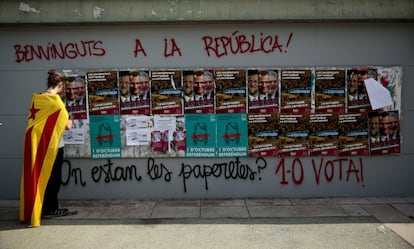 Un estudiante pega una pegatina en una pared al final de un acto en apoyo a 1 de octubre de 2017.