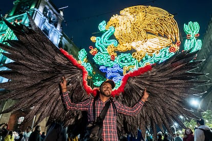 Una persona con alas de águila frente a la iluminación del primer cuadro de la ciudad.