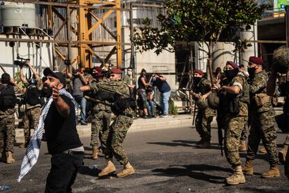 Manifestantes se interponen entre elementos violentos y el cordón militar durante la manifestación de este sábado en Beirut.