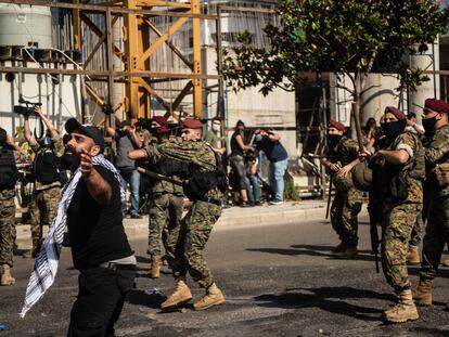 Manifestantes se interponen entre elementos violentos y el cordón militar durante la manifestación de este sábado en Beirut.