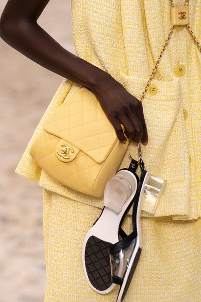 Chanel aboga tanto por el bienestar de los pies de sus modelos que las sacó a la pasarela (una playa improvisada en el Grand Palais parisino) totalmente descalzas. En la mano llevaban los zapatos de la colección: sandalias tipo pala con un discreto tacón de metacrilato.