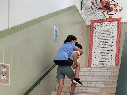 María Jesús Aguilar, subiendo a cuestas a su hijo Arturo, en el colegio Voramar