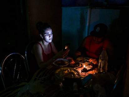 Una mujer ilumina su cena con su teléfono móvil durante un apagón en La Habana, en mayo de este año.