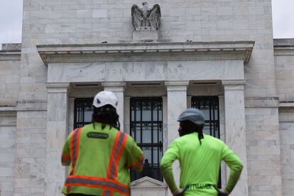 Dos trabajadores frente al exterior del edificio Marriner S. Eccles de la Reserva Federal, el 26 de julio en Washington.
