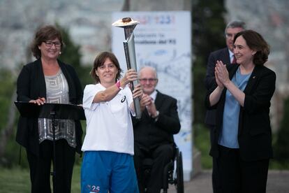 La primera portadora de la torxa olmpica, la medallista Eli Maragall, rep la torxa de mans de l'alcaldessa de Barcelona, Ada Colau.