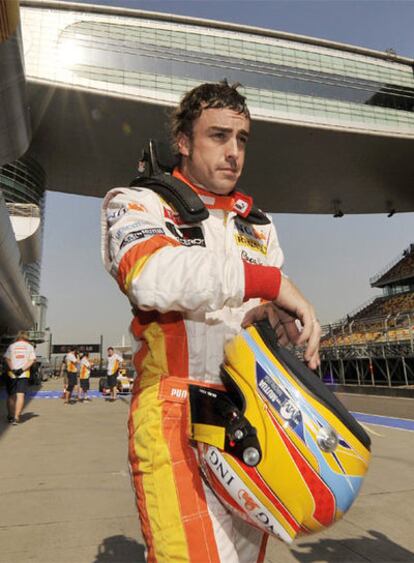 Fernando Alonso pasea por el <i>pit lane</i> tras la segunda sesión de entrenamientos libres de ayer.