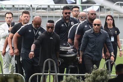 El hijo de Pelé Edinho (primero a la derecha), junto al exfutbolista Zé Roberto (izquierda) y algunos amigos participan en el velatorio de Pelé hoy, en el estadio Vila Belmiro en la ciudad de Santos (Brasil). 