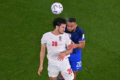 El jugador iraní, Sardar Azmoun, lucha un balón con el defensor estadounidense Cameron Carter-Vickers.