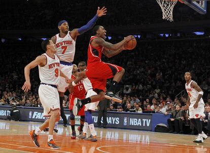 Jeff Teague de los Atlanta Hawks salta a canasta ante de los jugadores de los Knicks Carmelo Anthony (número 7) y Pablo Prigioni.