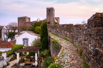 Adarve de la muralla de Óbidos (Portugal), con el castillo y la fachada de la iglesia de Santiago. 