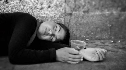 Una mujer romaní duerme en el suelo de una calle de Madrid.