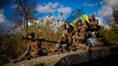 Soldados ucranios enarbolaban la bandera nacional a bordo de un vehículo armado que los transportaba el 4 de octubre desde Izium a Liman.