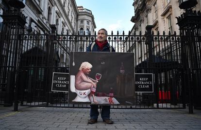 El artista de sátira política Kaya Mar posa para una foto sosteniendo su pintura del primer ministro británico, Boris Johnson, en las afueras de Downing Street en Londres, Gran Bretaña.