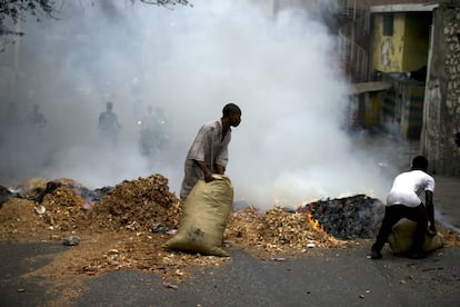 Manifestantes queman basura y aserrín en una barricada callejera durante la  protesta de oficiales de policía.