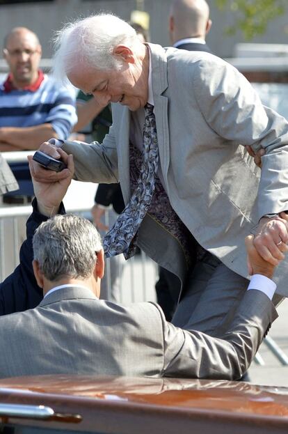 George Clooney ayuda a su padre, Nick, a subirse al bote que los lleva a su hotel en Venecia.