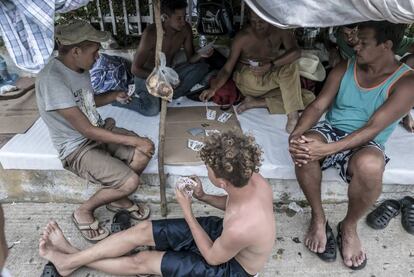 Un grupo de hondureños juega a las cartas mientras espera su próxima salida en Pijijiapan.