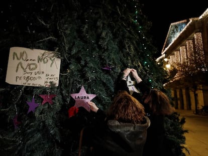 Dos mujeres colocan en un árbol de Navidad de la Plaza del Castillo en Pamplona dos estrellas, una de ellas con el nombre de Laura Luelmo y la otra con el numero de mujeres asesinadas este año.