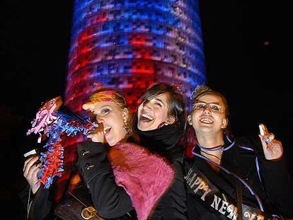 Tres jóvenes celebran la llegada del Año Nuevo al pie de la Torre Agbar, que tuvo poco éxito de concurrencia.