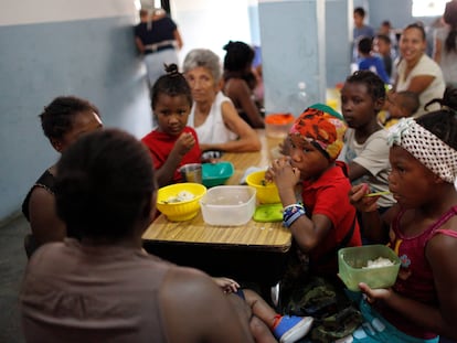 Un grupo de niños recibe alimentos en una cocina comunitaria financiada por una ONG, en Caracas (Venezuela).