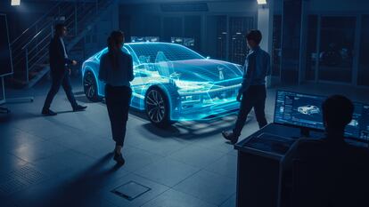 Ingenieros de automoción observan una proyección holográfica en 3D de un de coche.