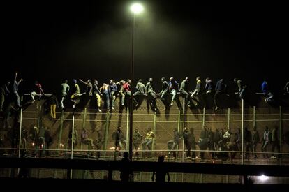 Um grupo de subsaarianos tenta saltar a cerca de Melilla, que separa Marrocos da Espanha, em 2014