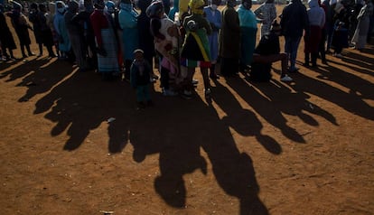 Una fila de personas que esperan una paquete de comida bajo el sol en Pretoria (Sudáfrica).
