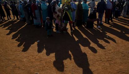 Una fila de personas que esperan una paquete de comida bajo el sol en Pretoria (Sudáfrica).