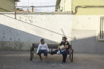 Andrei, sentado junto a su madre Karen después de hacer algunos recados por el barrio de Villaverde Alto (Madrid).