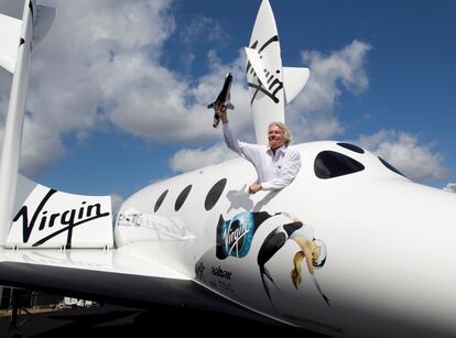Richard Branson posa para la prensa desde una réplica de SpaceShipTwo, una de las naves de su copañía Virgin Intergalactic.
