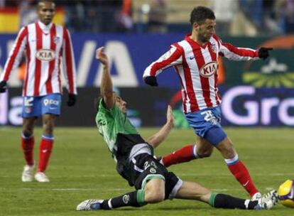 Simão, autor del primer gol del Atlético frente al Racing, profundiza con el balón a pesar de la entrada de Lacen.