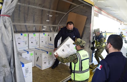 Militares descargan el avión de DHL que trajo más de 400.000 dosis a México.
