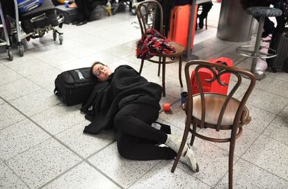 Una pasajera duerme en el suelo, en el aeropuerto de Gatwick en Londres (Reino Unido), tras la suspensión de los vuelos.